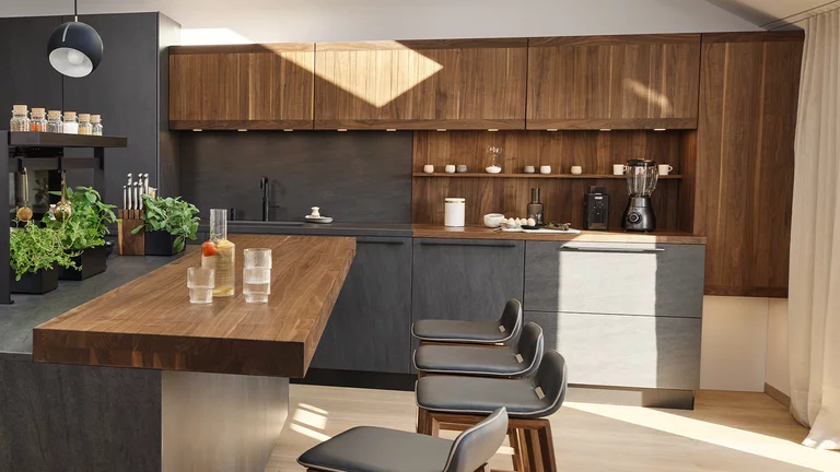 modern solid wood kitchen echt.zeit in walnut with ceramic fronts, bar top and bar stools