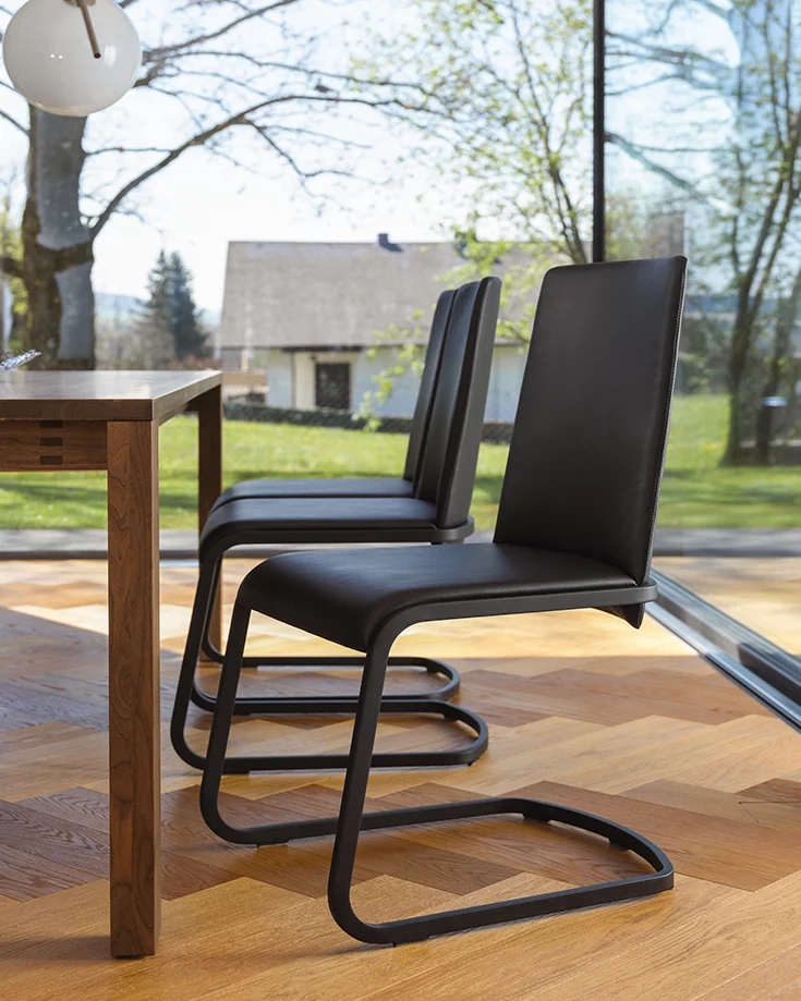 comfortable f1 cantilever chair upholstered with base frame in matt black and magnum dining table