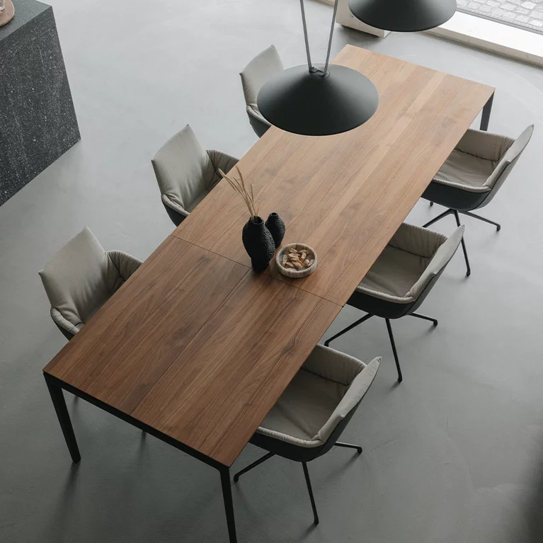 dining table tak made of solid wood and extendable in walnut with metal frame in matt black and the lui léger chair group