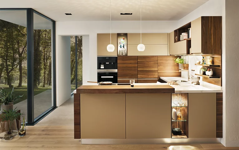 Massivholzküche linee in Nussbaum mit Farbglas Fronten in sand matt