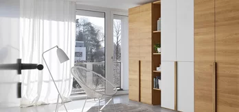 lunetto Drehtürenschrank in Eiche mit eleganten Winkelgriffleisten und Farbglasfronten