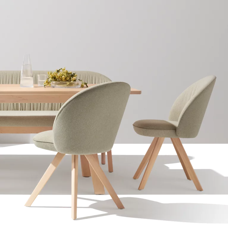 flor upholstered chairs in fabric with wooden frame in white alder, taso table and the flor bench