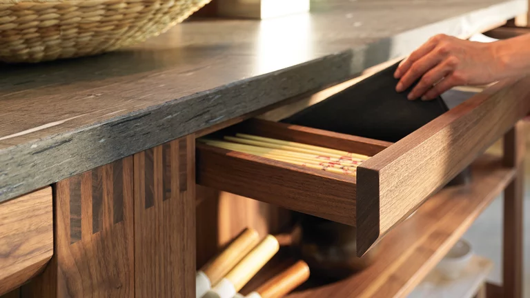 loft kitchen in wild walnut with drawer and worktop in natural stone in the colour brown silk, detailed view