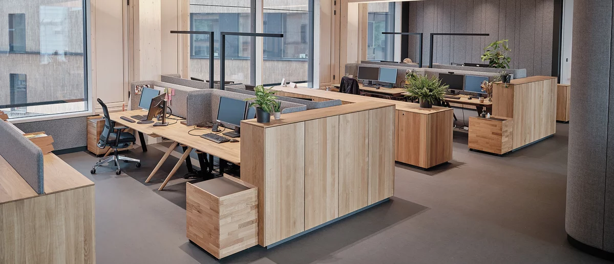 Höhenverstellbare pisa Schreibtische mit Stoffblende, Rollcontainer und filigno Sideboards in Eiche Massivholz