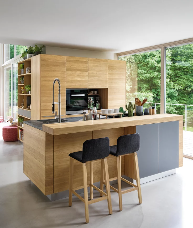 linee Massivholzküche in Eiche mit Farbglas Fronten mittelgrau matt, Arbeitsplatte aus Naturstein und Barelement mit ark Barhockern