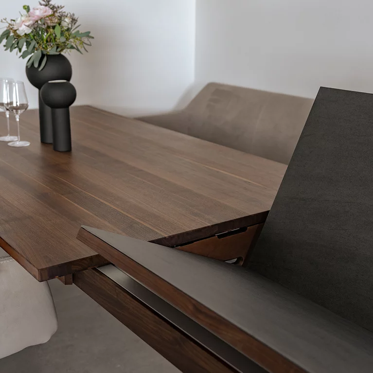 Massivholz Ausziehtisch mit patentierter Ausschwenktechnik für die Einlegeplatten magnum Ausziehtisch aus Nussbaum Massivholz bei dem sich die Einlegeplatten dank patentierter Technik komfortabel ausschwenken