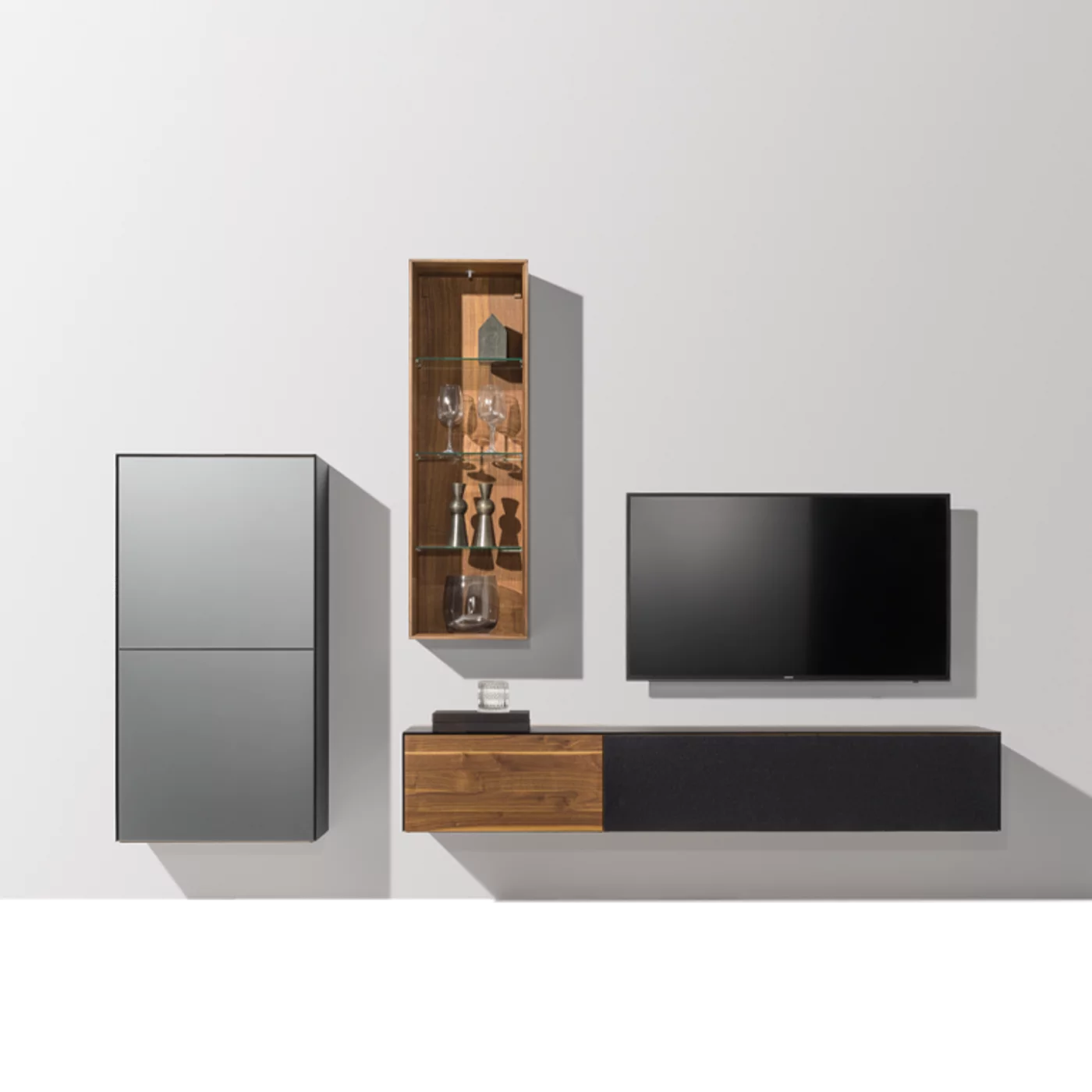 hängende Wohnwand in Vollholz Nussbaum mit unterschiedlichen Glasfarben,Glasfachboden und Beleuchtung