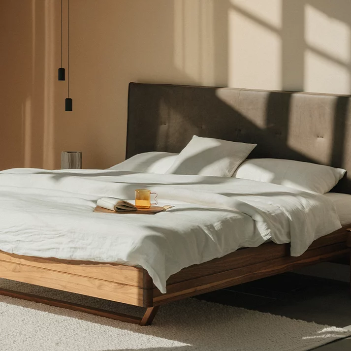 Holzbett float in Nussbaum massiv mit Lederkopfhaupt und dem float Nachtkästchen