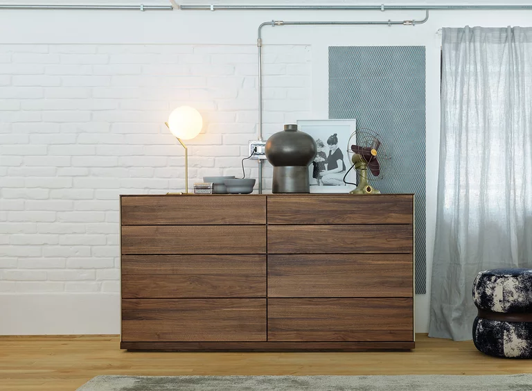 riletto chest of drawers in walnut with leather side panels in the colour pebble
