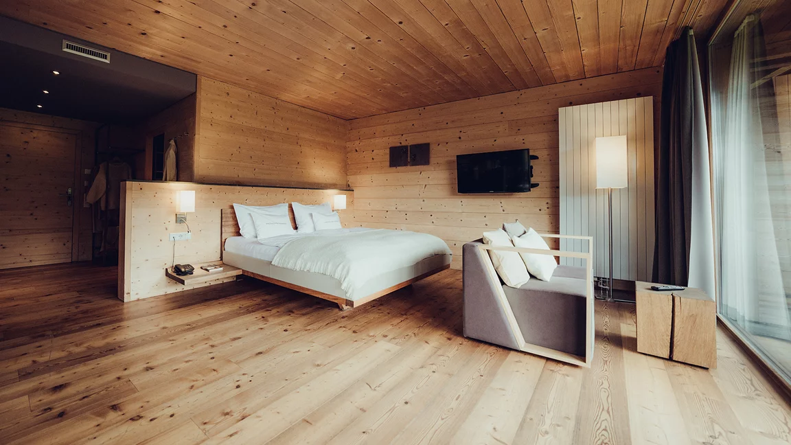 modernes riletto Massivholzbett mit Lederwangen und Konsolen in Schwebeoptik und Naturholzblock als Beistelltisch