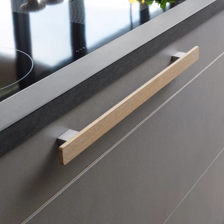 Küche aus Vollholz mit elegantem Holzgriff und Keramik Fronten, Detailansicht Küche cera line in Eiche Weißöl mit elegantem Holzgriff mit Keramik Fronten in cement, Detailansicht