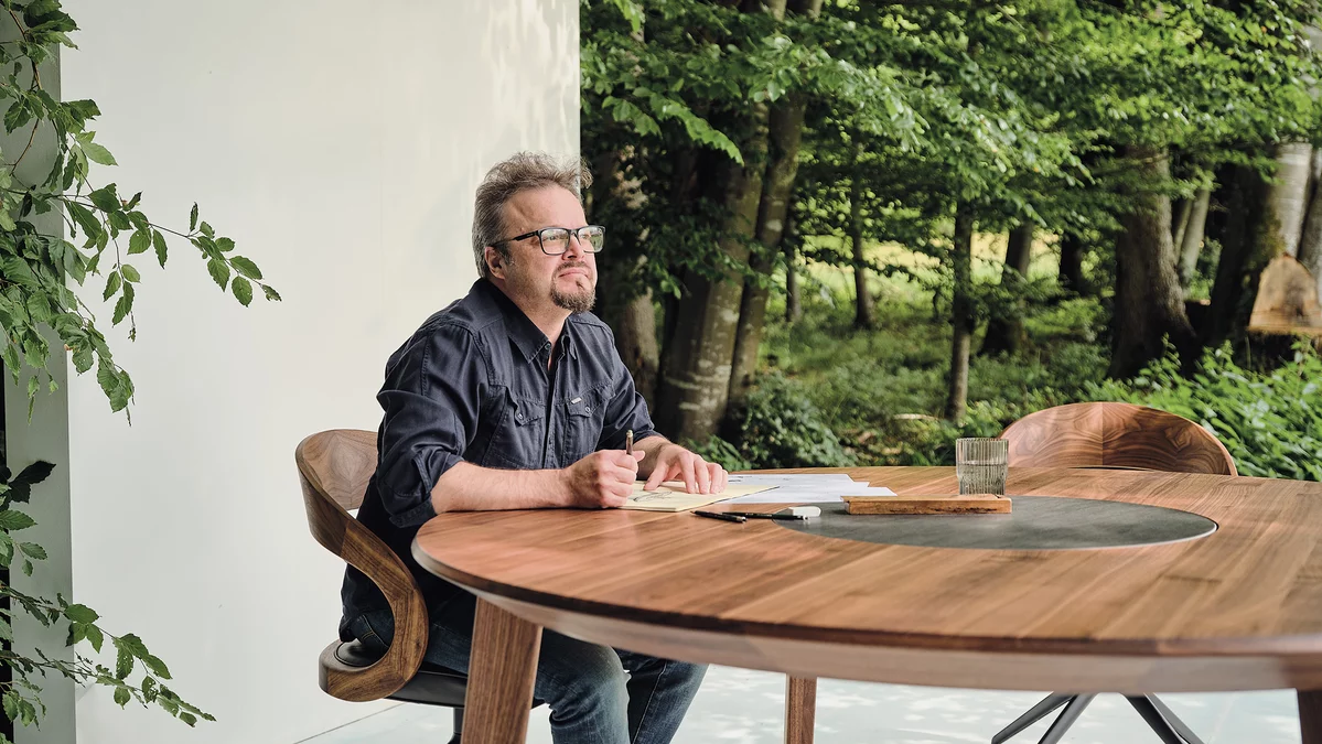 Designer Sebastian Desch mit dem selbstdesignten miró Esstisch in Nussbaum