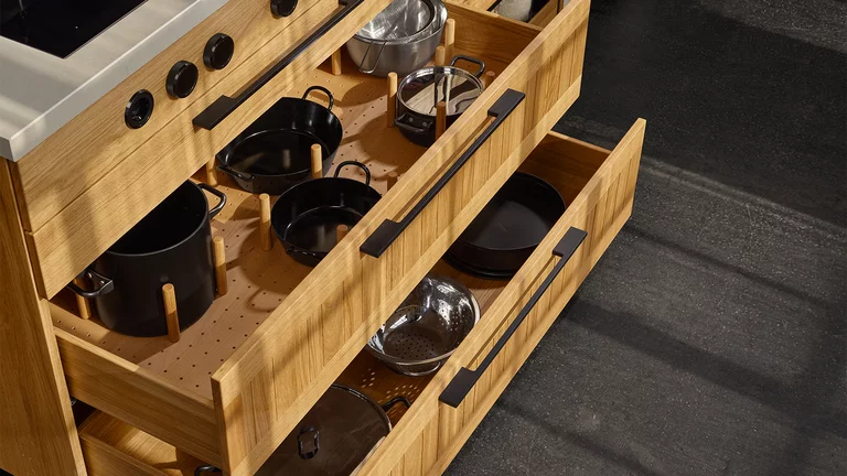 large drawers in oak disc base with spacers and metal handles in black stainless steel finish
