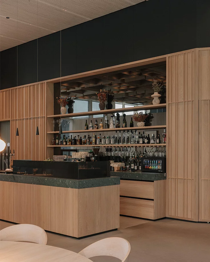 Elegant bar counter with ceramic worktop and mirror back panel in solid oak