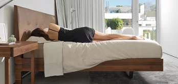 float wooden bed in solid walnut with leather headboard, aos sleep system and the float bedside cabinet