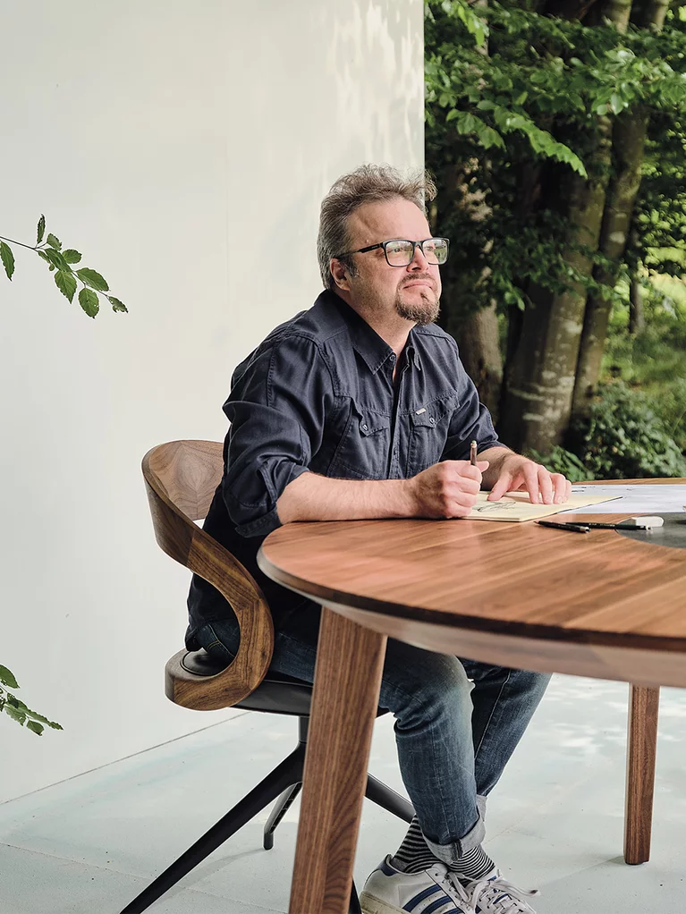 Designer Sebastian Desch with the self-designed miró dining table in walnut